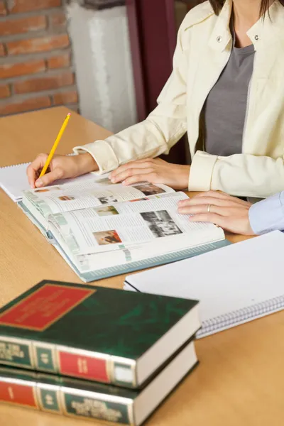 Studenti che studiano a tavola in biblioteca — Foto Stock