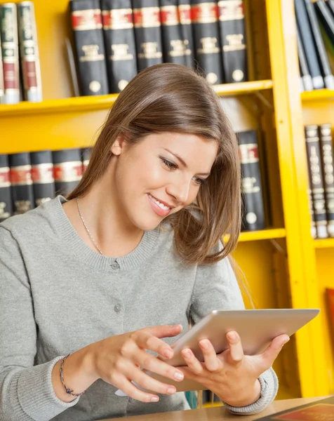 Mujer usando tableta digital en la biblioteca de la universidad — Foto de Stock