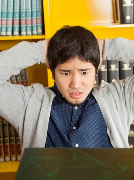 Student With Hands Behind Head Looking At Books In Library — Stock Photo, Image