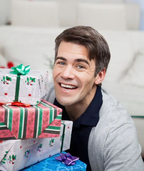 Lächelnder erwachsener Mann mit Weihnachtsgeschenken — Stockfoto