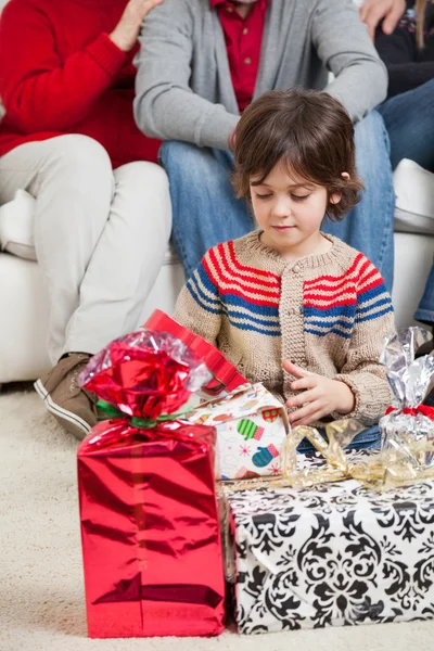 Pojken tittar på julklappar — Stockfoto