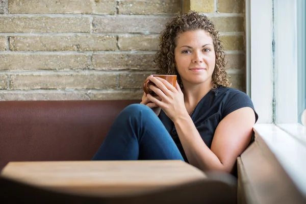 Mulher com caneca de café sentado na cafetaria — Fotografia de Stock