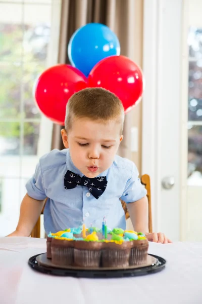 Chlapec foukání svíčky na dort — Stock fotografie