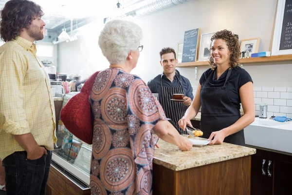 Propietario con colegas y clientes en el mostrador de café — Foto de Stock