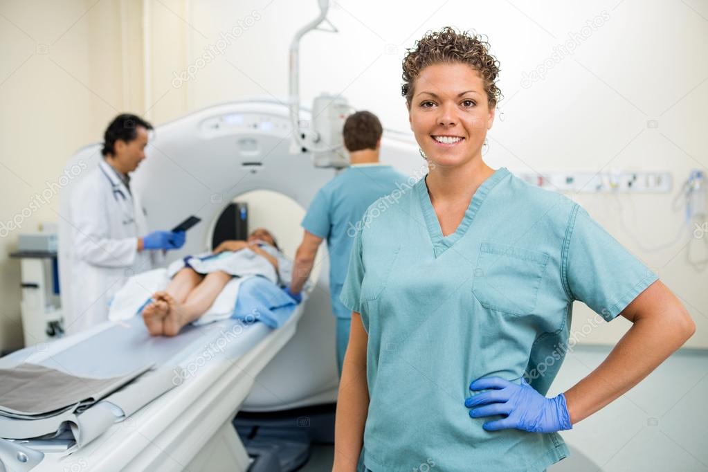 Nurse With Colleague And Doctor Preparing Patient For CT Scan