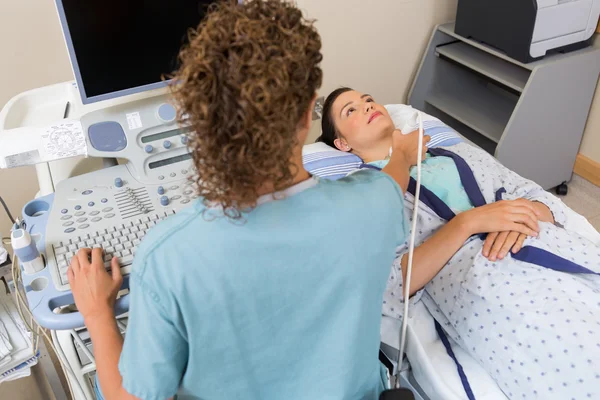 Enfermera realizando ecografía en el cuello del paciente — Foto de Stock