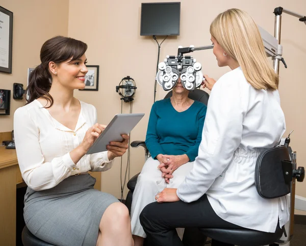 Ophthalmologists Examining Senior Woman In Store — Stock Photo, Image