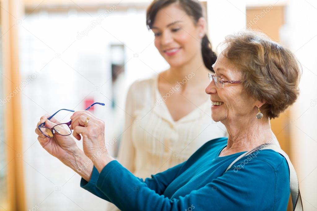 Senior Woman Holding New Glasses In Store