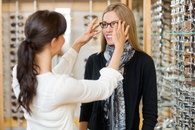 Salesgirl Assisting Customer To In Wearing Glasses clipart