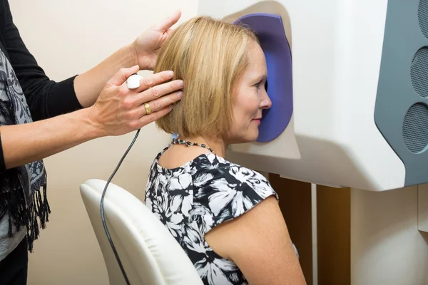 Optometrist aanpassen van patiënt hoofd voor retinale checkup — Stockfoto