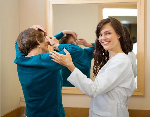 Oogarts bijstaan van de vrouw om in te voegen contact lens — Stockfoto