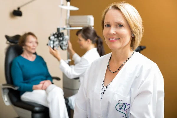 Selbstbewusster Augenarzt mit Kollegin untersucht Patientin — Stockfoto