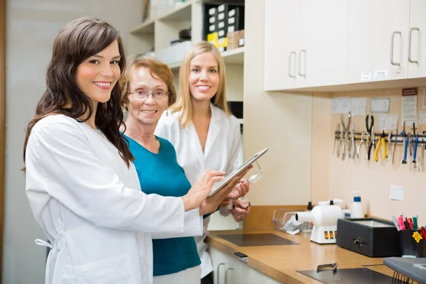 Ottici che utilizzano la tavoletta digitale in officina — Foto Stock