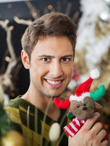 Homem segurando brinquedo recheado na loja de Natal — Fotografia de Stock