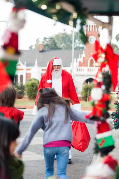 Crianças correndo para abraçar Papai Noel — Fotografia de Stock