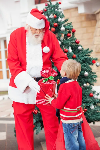 Babbo Natale che fa un regalo al ragazzo — Foto Stock