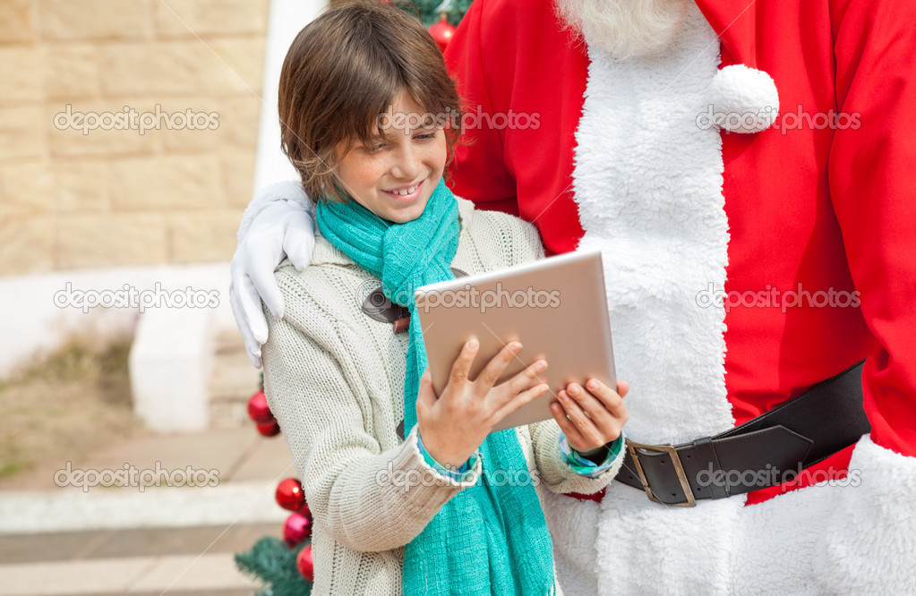 Santa Claus And Boy Using Digital Tablet