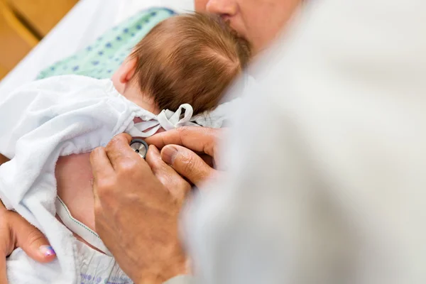 Les mains du médecin examinant Babygirl avec stéthoscope — Photo