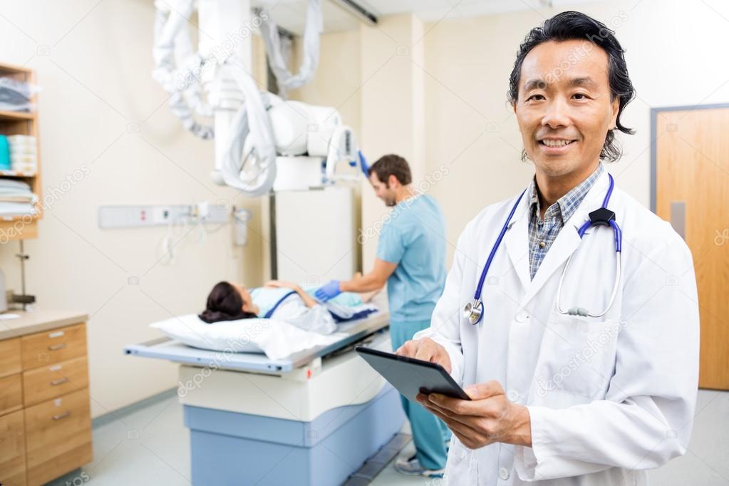 Doctor Using Digital Tablet In Hospital Room