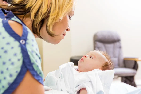 Vrouw op zoek naar leuke pasgeboren babygirl in ziekenhuis — Stockfoto