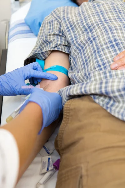 Doutor tirando sangue do braço do paciente — Fotografia de Stock