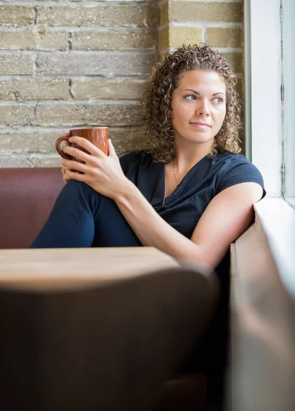 Frau blickt durch Fenster in Cafeteria — Stockfoto