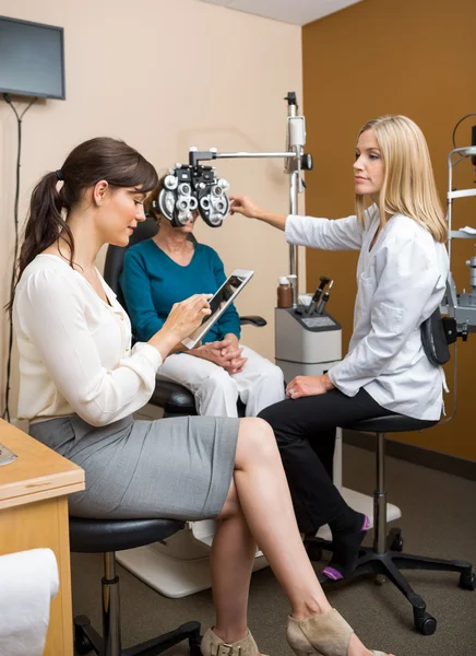 Optometristas examinando al paciente en la tienda — Foto de Stock