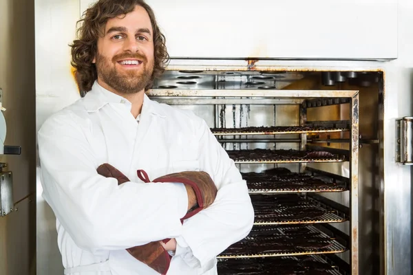 Carniceiro de pé braços cruzados por forno — Fotografia de Stock