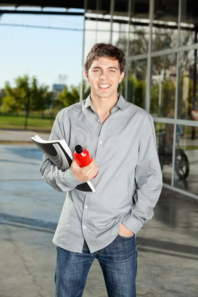 Student houden boek en SAP fles op de campus — Stockfoto