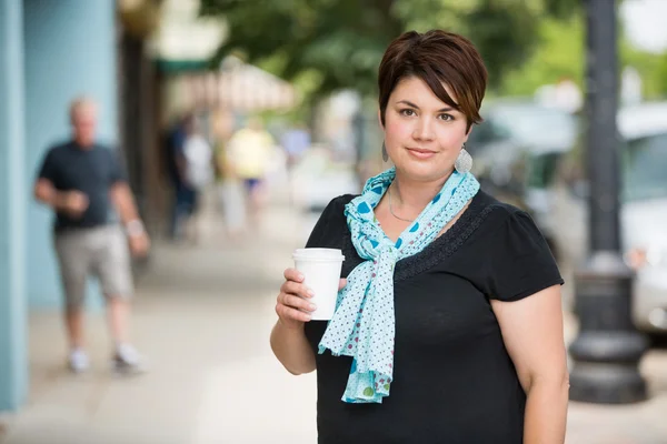 Femme avec tasse de café jetable sur la chaussée — Photo