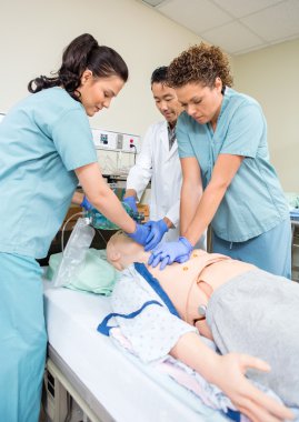 Medical Team Performing CPR On Dummy clipart