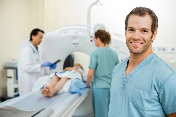 Krankenschwester mit Kollegin und Arzt bereitet Patientin auf CT-Scan vor — Stockfoto