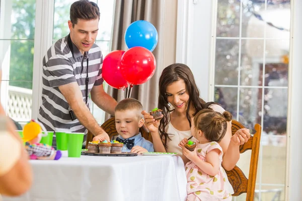 Familie eten cupcakes op verjaardagsfeestje — Stockfoto