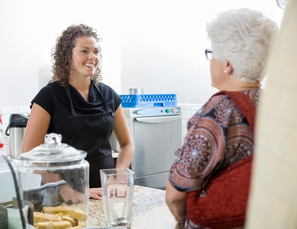 Café eigenaar bijwonen senior vrouw — Stockfoto