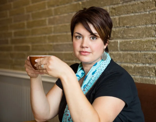 Belle femme tenant tasse de café dans le café — Photo