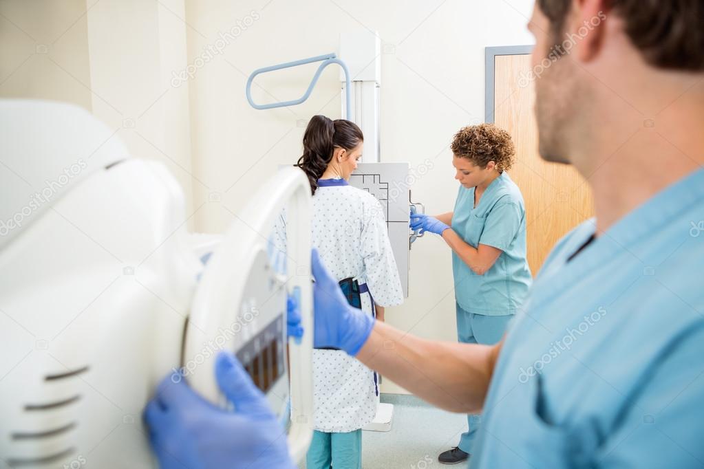 Nurses Adjusting Chest Xray Machines For Patient