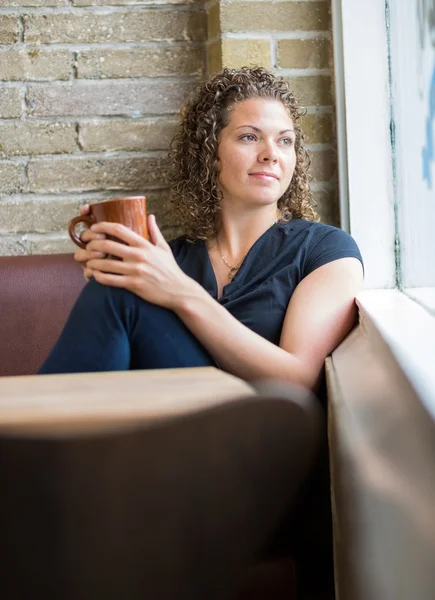 Vrouw met koffiemok in cafetaria — Stockfoto