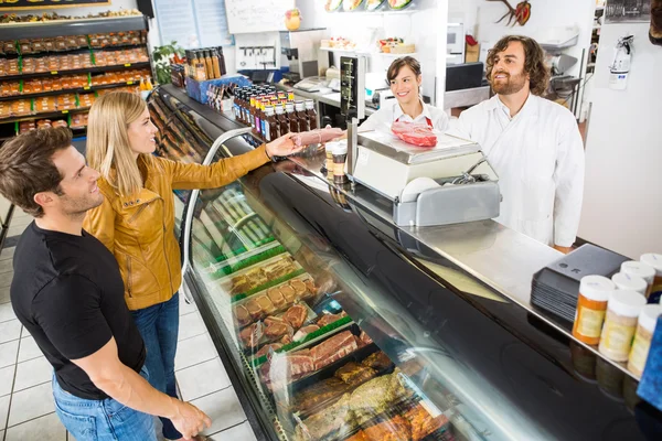 Paar kauft Fleisch beim Verkäufer im Geschäft — Stockfoto