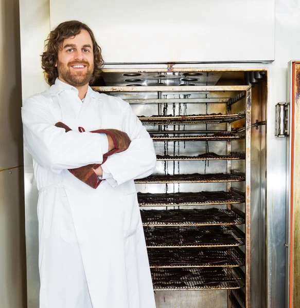 Boucher debout bras croisés devant fumeur — Photo