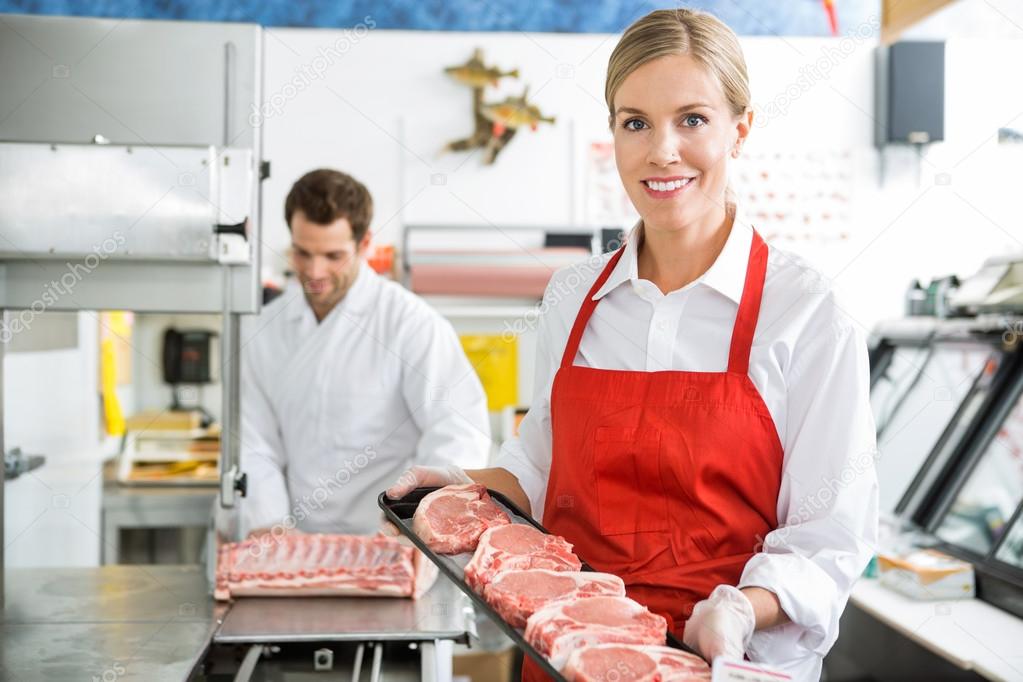 Beautiful Butcher Holding Meat Tray In Store