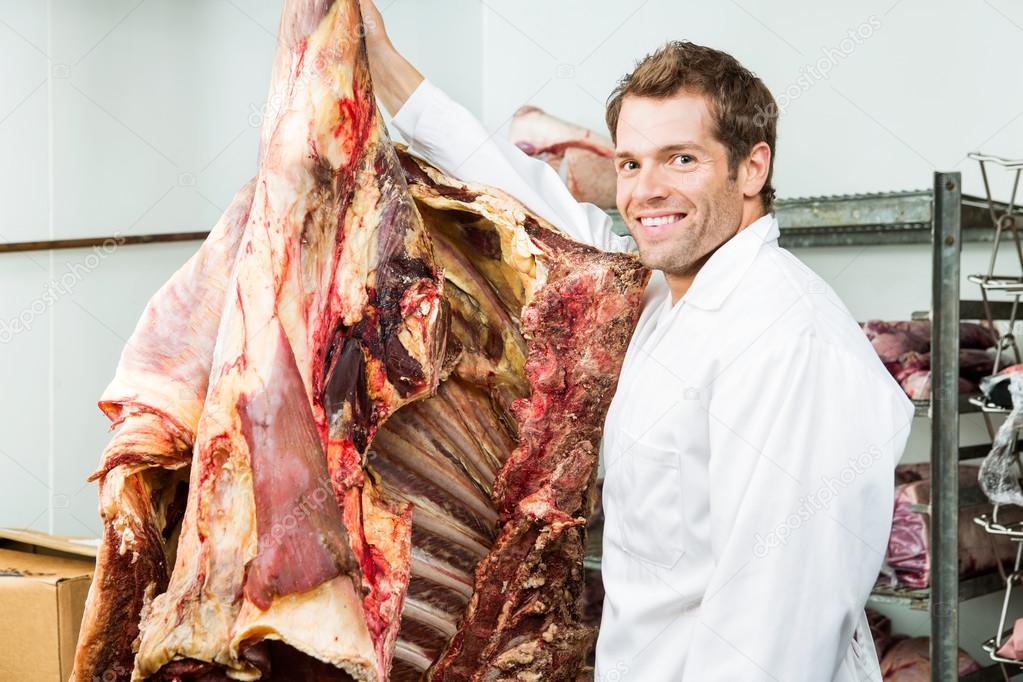 Butcher Standing Beside Beef in Cooler