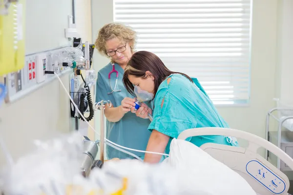 Donna incinta, respirando attraverso la maschera di ossigeno mentre assisti infermiera — Stockfoto