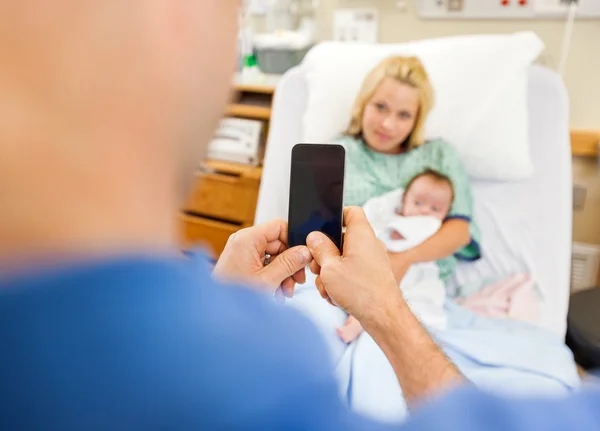 Homem fotografando mulher e babygirl através do telefone celular — Fotografia de Stock