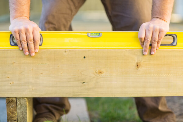 Carpenter's Hands Using Spirit Level On Wood