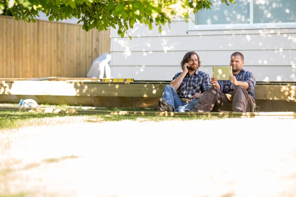 Worker Using Digital Tablet While Coworker On Call At Site — Stock Photo, Image