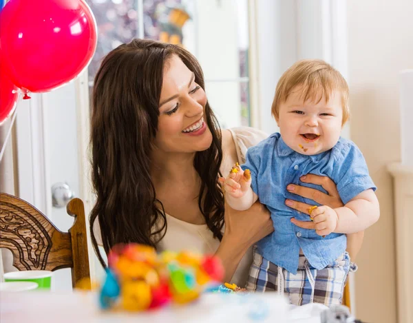 Mãe segurando bebê menino na festa de aniversário — Fotografia de Stock