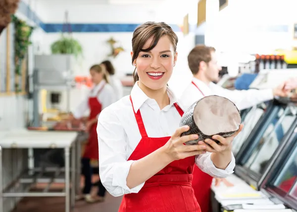 Gelukkig vrouwelijke slager houden grote ham — Stockfoto