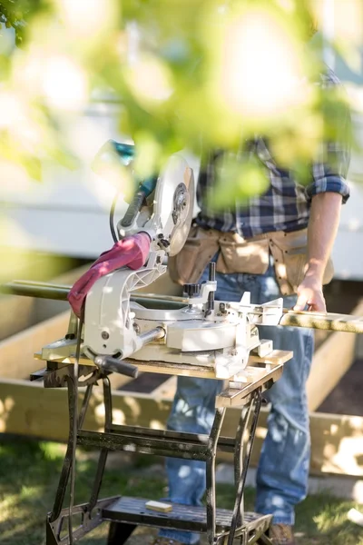 Lavoratore che tiene Plancia di legno a tavola sega — Foto Stock