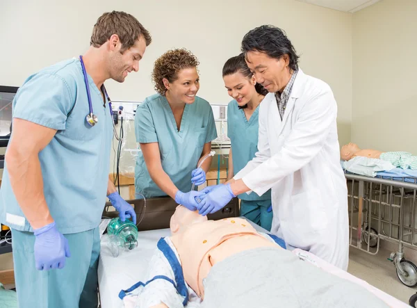 Equipo médico que ajusta el tubo en la boca del paciente maniquí — Foto de Stock