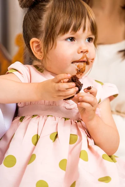 Compleanno ragazza mangiare torta con ghiaccio su il suo faccia — Foto Stock